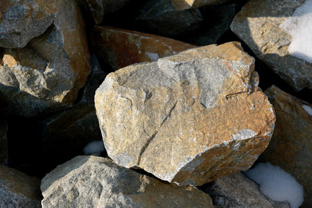 Textured boulders catch golden rays along a rugged shore.