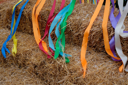 Brightly colored ribbons sway gently from straw bales at a lively celebration.の写真素材