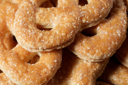 Delicious golden pretzels with sugary glaze tempt passersby, freshly made.の写真素材
