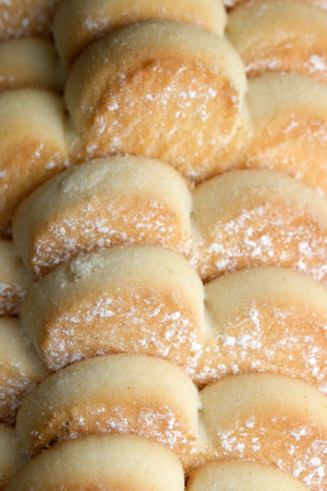 A tray filled with freshly baked golden pastries sits on a wooden table, capturing the warm...