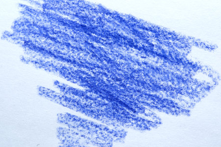 Vibrant blue chalk strokes create an abstract pattern on textured paper.の写真素材