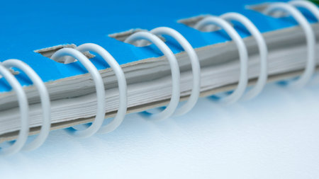 Blue spiral notebook lays open on a clean white surface, ready for notes.