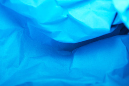 Vivid blue paper rolls form a textured, colorful landscape.