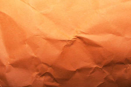 Textured crumpled brown paper provides a warm, creative backdrop for crafts.の写真素材
