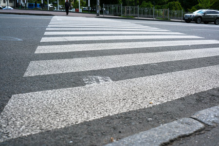 A busy city intersection features a prominent crosswalk guiding pedestrians safely across.の写真素材