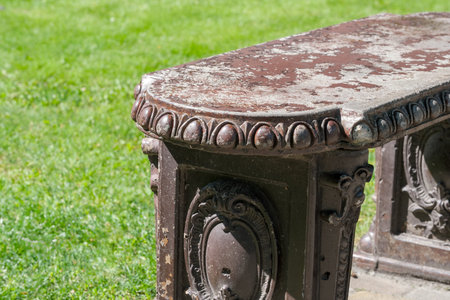 A vintage bench shows character and charm in a serene green park setting.の写真素材