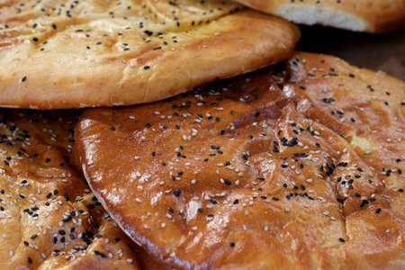 Warm bread loaves with a golden crust and sprinkled seeds are ready for enjoyment.