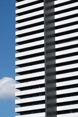 This striking building features bold lines and contrasting colors against clouds.