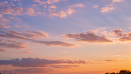 Golden rays blend with clouds, creating a serene twilight above a calm horizon.の素材