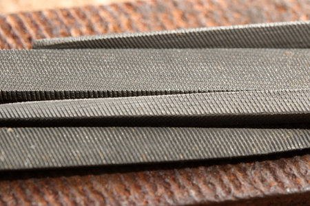 Close-up of metal files on a weathered wood surface, showcasing craftsmanship.
