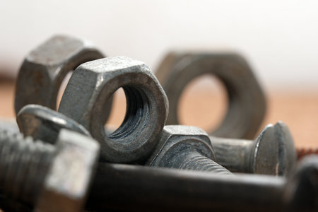 Various nuts and bolts are creatively positioned on a wooden background.