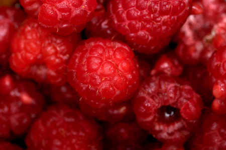 Vibrant raspberries glisten with water droplets, showing nature's beauty.