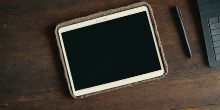 A workspace features a tablet and pen on a wooden desk, inviting inspiration.の素材