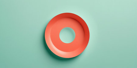 A vibrant round plate rests against a soft mint green background, inviting creativity.の素材