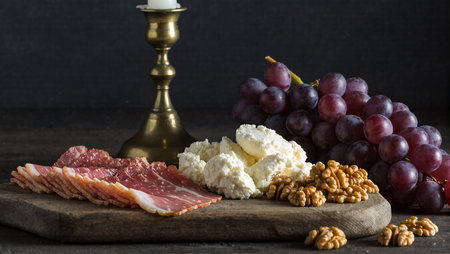 Charcuterie board showcases cured meats, creamy cheese, grapes, and nuts beautifully.の素材