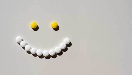 Round candies are arranged to form a cheerful smiley face in bright colors.の素材