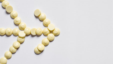 Yellow discs form an arrow on a white surface, indicating movement.の素材