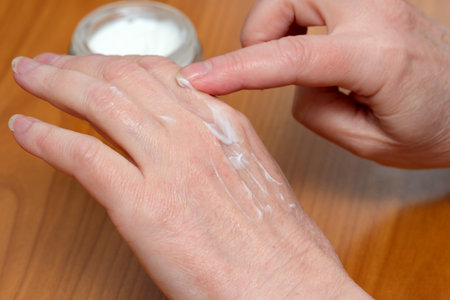 Hands applying rich moisturizer on skin for hydration and softness.の写真素材
