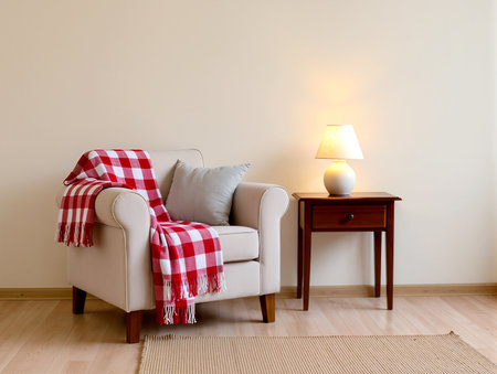 A comfy armchair with a blanket waits beside a lamp in a tranquil room.の素材