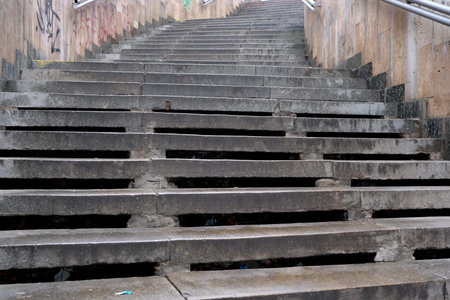 Rain-soaked steps with wear and tear guide the way through a cityscape.