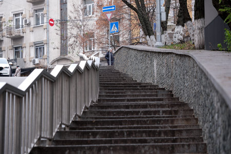 Winding steps rise toward a bustling street, framed by urban architecture.