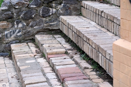 Weathered bricks form charming steps, surrounded by rugged stone and greenery.