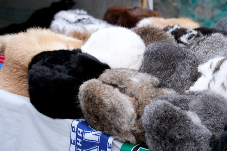 Soft and cozy fur hats rest on a table at a vibrant market scene.の写真素材
