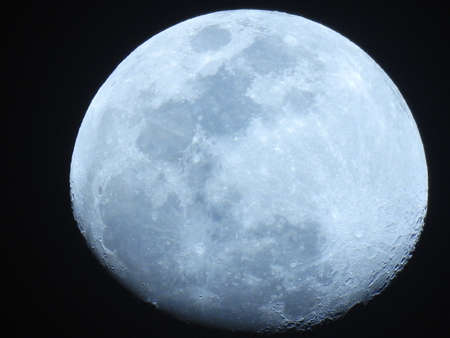 More than half light blue moon on black background.の写真素材