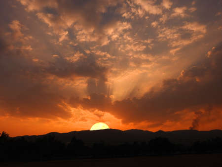 Sun set down behind thai temple on mountain.の写真素材