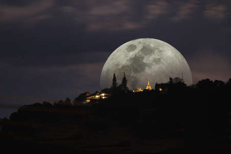 full Moon down behind thai temple on mountain.の写真素材