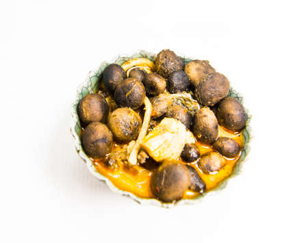 Red curry chicken in coconut milk with puff ball earthstars mushroom and bamboo shoot in green bowl isolated on white background.の写真素材