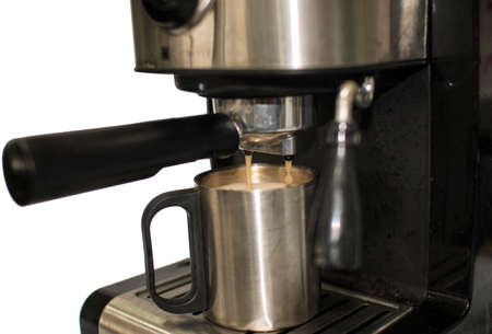 Automatic coffee  maker machine pouring  hot latte in to aluminum cup.の写真素材