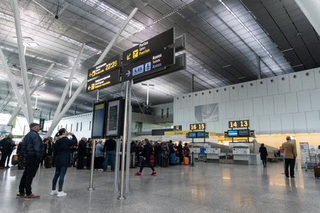 Santiago de Compostela, Spain. April 19 2019: Santiago de Compostela airport. Interior of the passenger terminal. Waiting hall, flights information board and Traveling passengersのeditorial素材