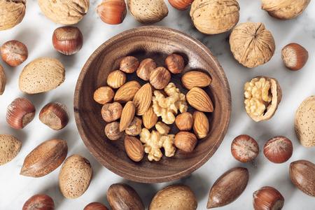 Nuts Mixed in a wooden plate.Assortment, Walnuts,Pecan,Almonds,Hazelnuts. Healthy appetizerの写真素材