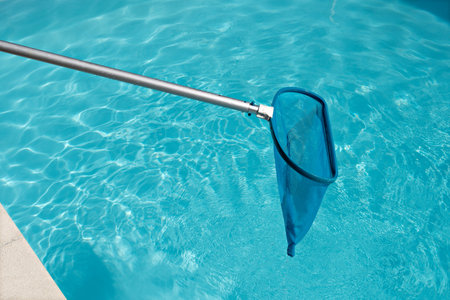 Pool Skimmer on bright water surface in swimming pool. Cleaning pool concept