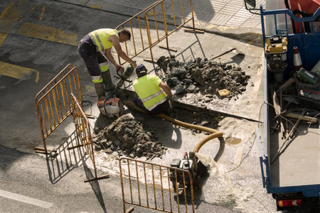 Galicia, Spain; August 02, 2018: Workers repairing a broken water pipe on the road