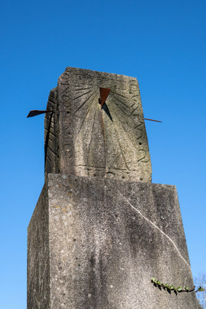 Ancient sundial isolated made of granite stone on blue sky