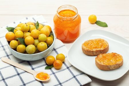 Pot of homemade sweet jam and toasts on wooden table. Delicious marmalade still lifeの写真素材
