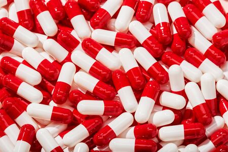 Pill capsule background. Lots of white and red pills. Medicine, healthcare and pharmacy conceptの写真素材