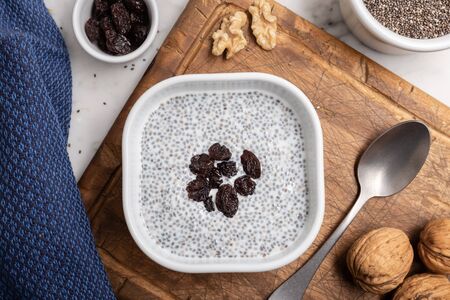 Chia seeds with milk and raisins. Chia pudding on table. Super food. Top viewの写真素材