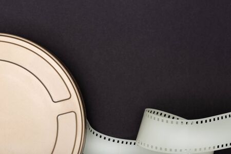 Motion Picture Film Can and film strip on black background. Movie or TV background. Top view, Copy spaceの写真素材