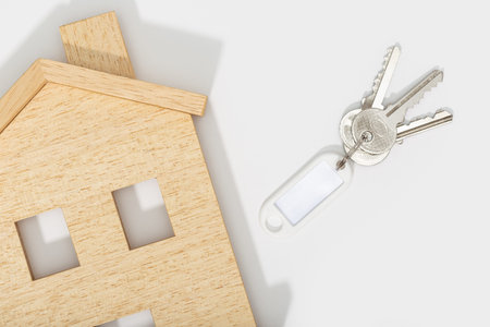 Real estate concept. House icon with keys on white background. Mock up. Copy space. Top view