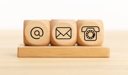 Contact us concept. Wooden blocks with email, mail and telephone icons.Website page contact us or...