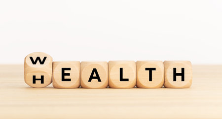 Wealth or Health concept. Turning wooden dice with text. Copy space