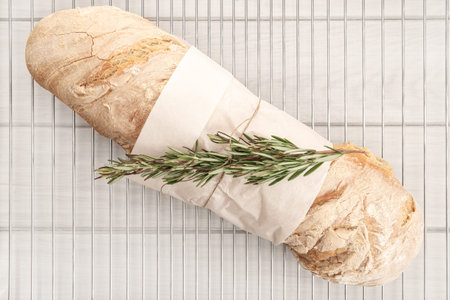 Homemade loaf of bread on white wooden background. Rustic bakery
