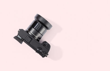 Top view of digital camera isolated on pink background. Copy space