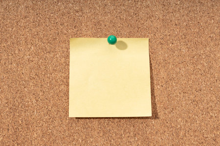 Cork board with blank yellow note for adding text and push pin. Mock upの写真素材