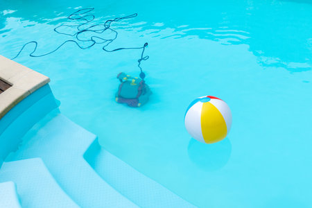 Underwater Robot cleaning a swimming pool and a inflatable ball floating . Maintenance pool concept. Copy spaceの写真素材