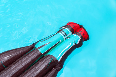 Coke shape inflatable Floating on water surface of a swimming pool. Summer background. Copy space