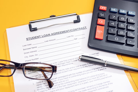 Blank Student Loan Application, calculator, pen and eyeglasses on table. Education cost concept